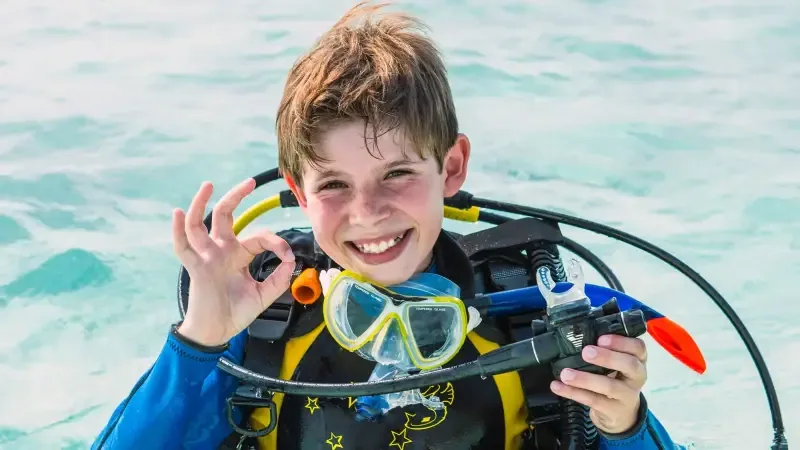 Happy young diver giving the OK sign during the Bubblemaker program