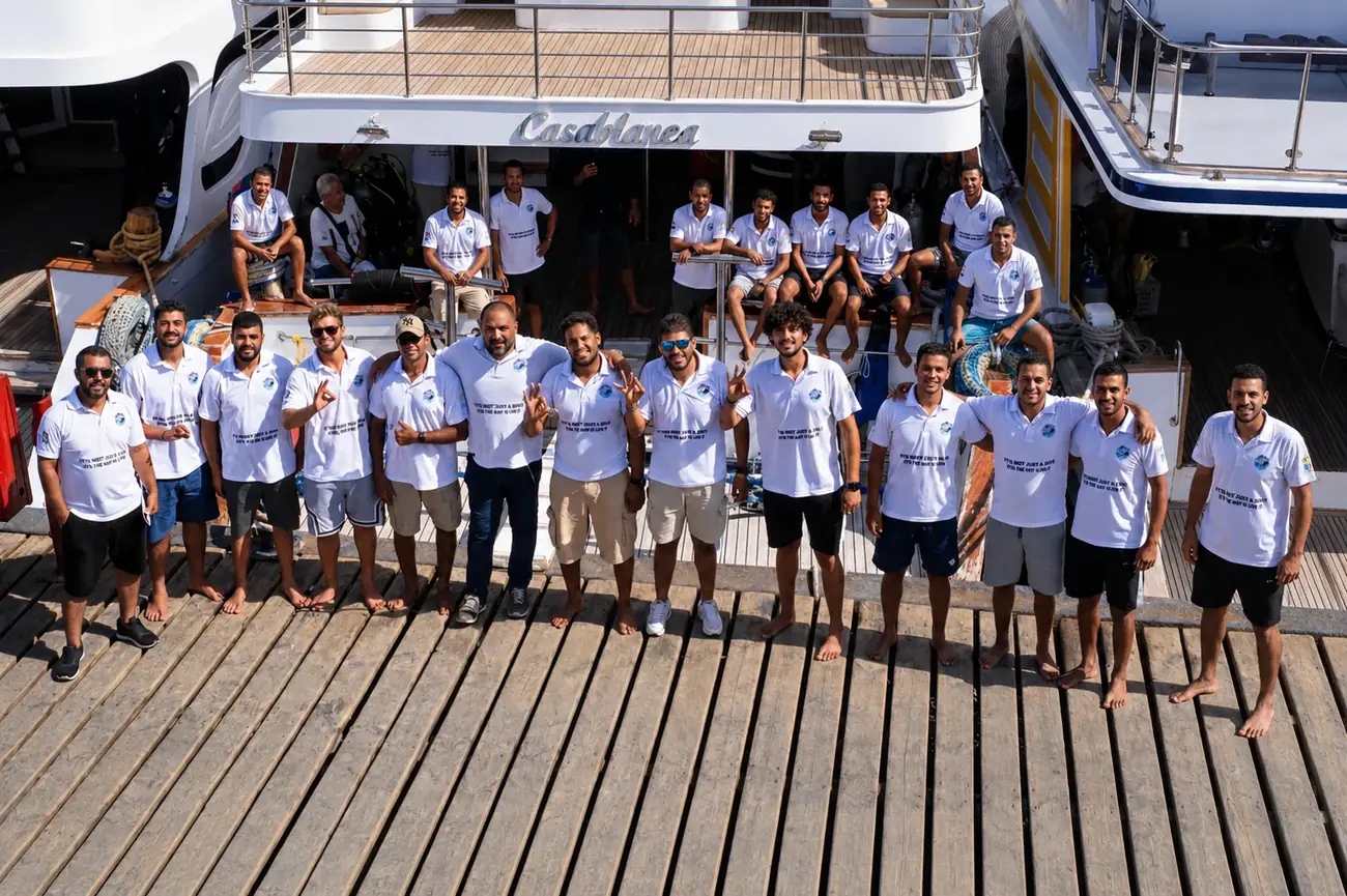 The full team of instructors and guides at The Wave Diving Center aboard the dive boat